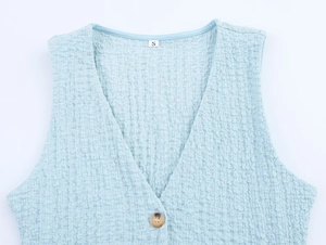 Detail of light blue seersucker vest with V-neckline, marble button and size S label