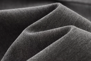 Gros plan sur la texture du tissu sergé gris montrant le tissage détaillé de l'ensemble