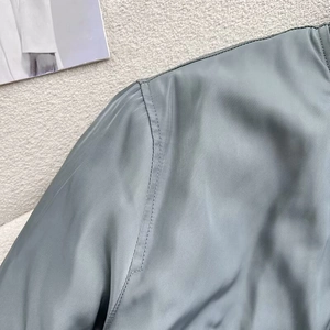 Detail of gray-blue bomber jacket featuring stand collar and precision double stitching