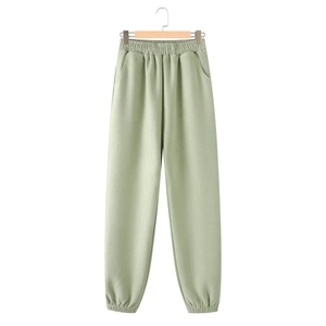 Detail of light green drawstring joggers featuring elastic waist and side pockets