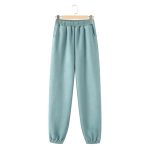 Detail of light blue high-waist sweatpants with elastic waistband and side pockets