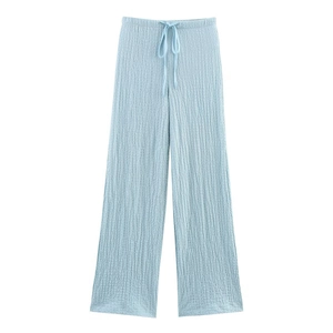 Detail of light blue wide-leg trousers featuring a vertical pleated texture and drawstring waist