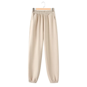 Detail of beige high-waist joggers featuring elastic waistband and functional side pockets