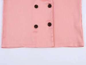 Detail of pink textured fabric with double-breasted dark amber buttons on a suit jacket