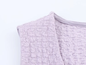 Detail of lavender v-neck vest showing premium crinkled texture and refined stitching