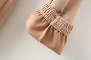 Detailed close-up of camel faux suede jacket sleeve with elastic pleated cuffs and fine stitching