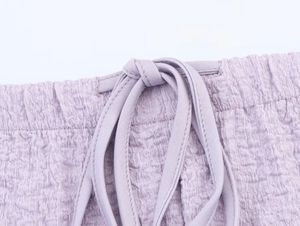 Close-up of lavender crinkled seersucker fabric with elastic waistband and drawstring detail