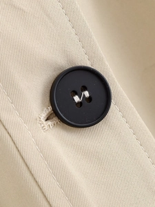 Macro shot of khaki trench coat fabric detail with high-quality black resin button
