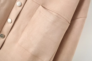Detailed macro view of beige suede jacket with metallic silver buttons and square pocket
