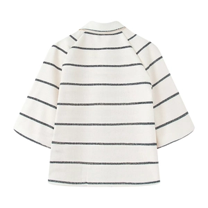 Close-up of woven textured fabric with black horizontal stripes on a beige cropped top