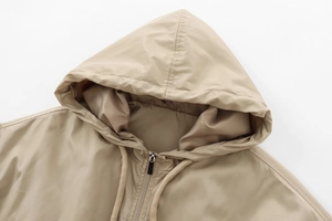 Detailed view of khaki drawstring hood and metal zipper on the casual autumn jacket