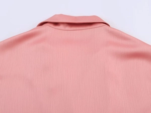 Close-up of pink long sleeve suit jacket back collar with fine vertical texture fabric