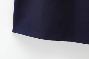 Dettaglio dell'abito corto blu navy che mostra la trama del tessuto e le cuciture fini