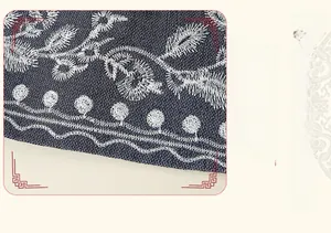 Detail shot of navy denim vest hem featuring exquisite white floral embroidery and neat stitching