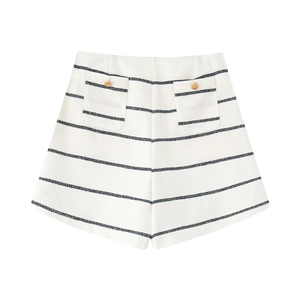 Detail of high-waist striped shorts featuring gold buttons and tweed texture