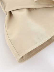 Close-up of high-density twill cotton fabric with neat stitching on a beige trench coat