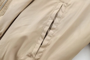 Detail view of khaki jacket fabric with high-quality stitching on slanted pocket