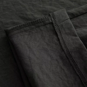 Dettaglio ravvicinato delle cuciture professionali sui pantaloni neri a vita alta