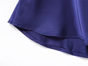 Detailed close-up of dark blue satin fabric hem with high-quality stitching and smooth texture