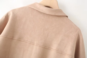Detail of light camel faux suede jacket featuring neat stitching on back collar and shoulder