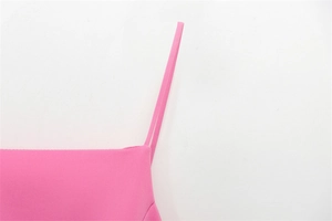 Dettaglio della fine trama del tessuto rosa e delle cuciture delicate sulla spallina sottile