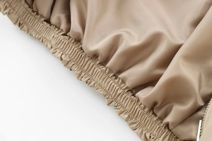 Detailed macro view of khaki jacket elastic hem with silver metal zipper teeth