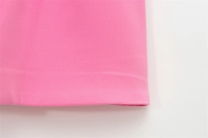 Primo piano dell'orlo dell'abito rosa che mostra cuciture di qualità e trama del tessuto