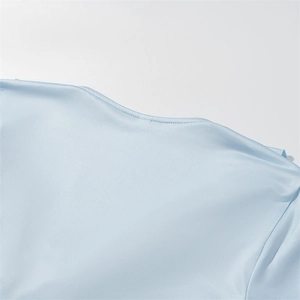 Close-up of light blue summer top showing fine neckline stitching and fabric texture
