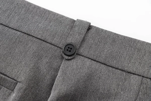 Détail du tailleur gris avec gilet col V montrant la texture du tissu et le bouton