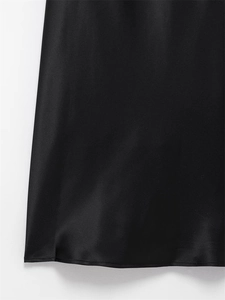 Close-up detail of smooth black satin dress hem with professional stitching finish
