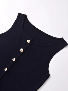 Detail of navy rib-knit vest featuring polished gold buttons and fine fabric texture
