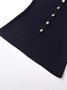 Detail of navy knit vest showing ribbed texture, gold buttons, and a stylish side slit hem