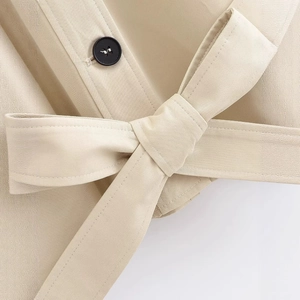 Women's khaki short trench coat with stylish waist belt and black button details