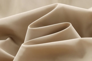 Detailed macro view of beige grid-textured fabric with durable and flexible draping folds