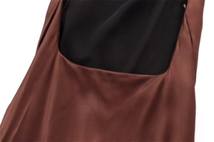 Detail of the smooth dark brown satin fabric texture and premium stitching on dress