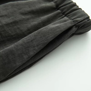 Dettaglio dell'elastico in vita grigio scuro e tasca laterale su pantaloni in cotone