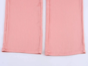 Detail of pink ribbed trouser hem showing the textured fabric and clean stitching
