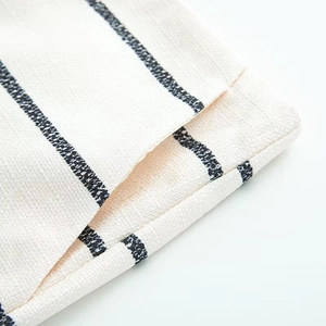 Close-up of beige cotton linen fabric showing striped texture and durable stitching detail