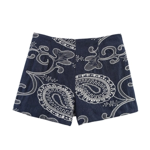 Détail de la broderie paisley blanche sur un short taille haute bleu marine à jambe large