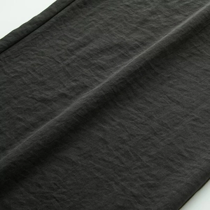 Dettaglio ravvicinato del tessuto grigio scuro di alta qualità con cuciture pulite sui pantaloni