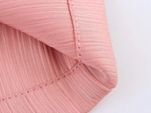 Macro detail of pink ribbed knit fabric with precise double-needle overlock stitching