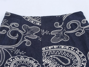 Détail du short en jean bleu foncé avec broderie paisley blanche et coutures fines
