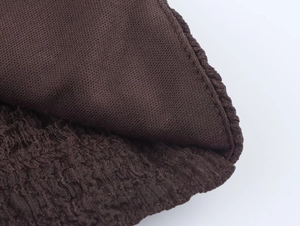 Detail shot showing dark brown pleated fabric and soft knitted lining with precise stitching