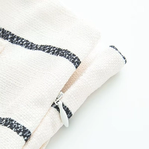 Detail of invisible zipper closure on cream and black striped textured fabric