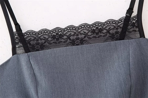 Detail of grey striped fabric with delicate black lace trim and thin straps