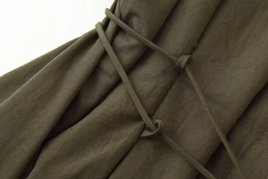 Macro detail of army green pleated dress fabric with textured drawstring waist tie