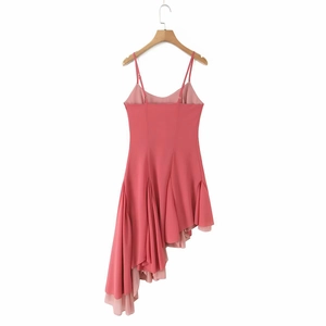 Detail of pink slip dress featuring layered ruffle hem and asymmetric irregular cut