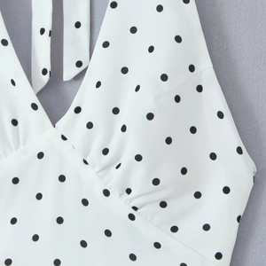 Détail du lien de cou licou et du décolleté en V profond sur cette robe blanche à pois