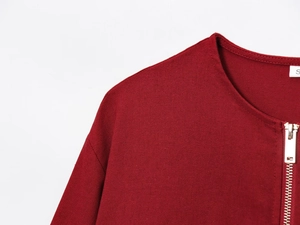 Close-up of deep red zipper jacket collar showing textured fabric and size S label
