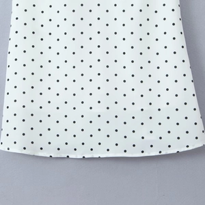 Détail du tissu à pois blancs avec ourlet incurvé et finitions de couture précises